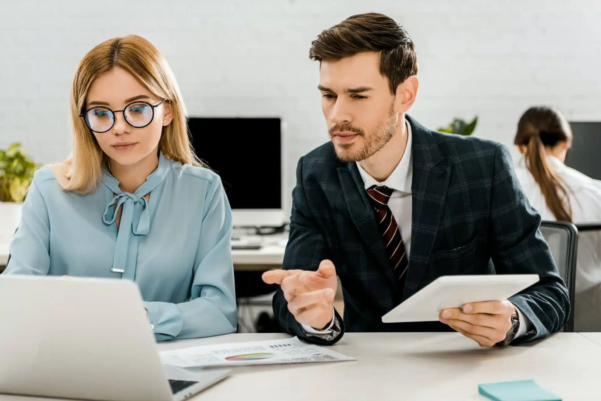 portrait of colleagues working at workplace with laptop in office