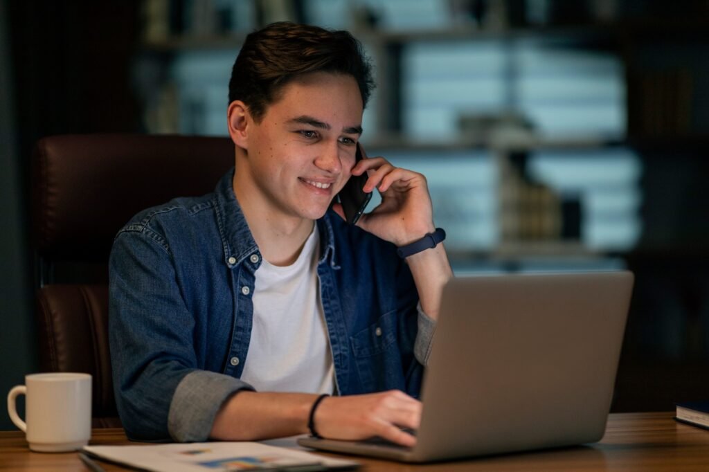 Cheerful young man working at office in the evening