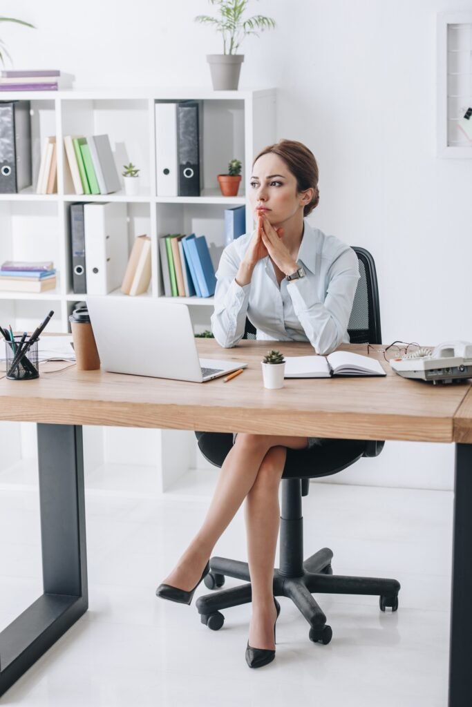 thoughtful confident businesswoman sitting at workplace in modern office