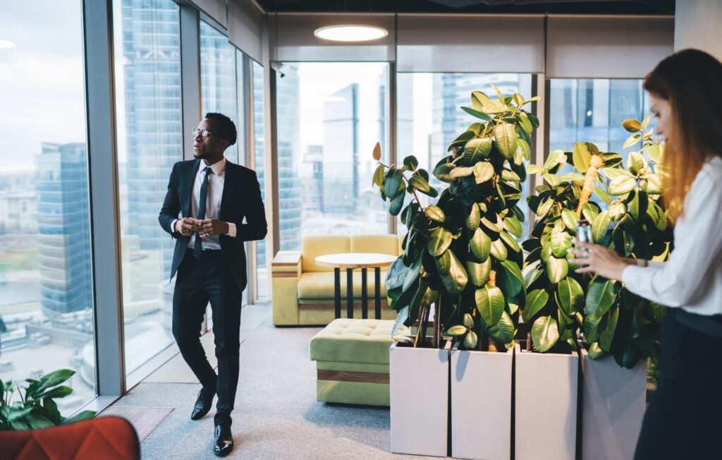 Ethnic businessman walking in office with modern furniture