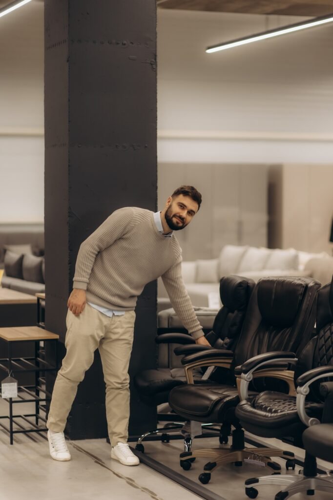 Man Examining Office Chairs in Modern Furniture Showroom