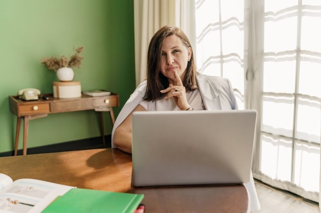 A woman analyst works online, designs a new startup, uses a laptop on the table. Workplace in a styl