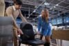In furniture store man and woman engage in discussion about different ergonomic office chair options