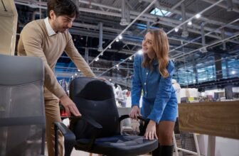 In furniture store man and woman engage in discussion about different ergonomic office chair options