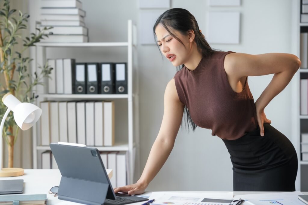 Young businesswoman in an office, sitting at her desk, working on a computer